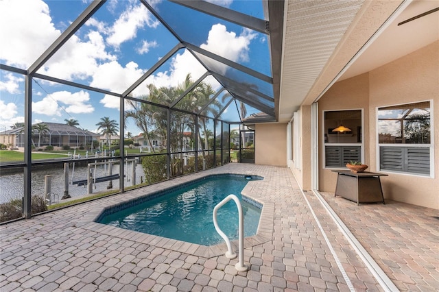 view of swimming pool with a water view, a patio, a dock, and glass enclosure