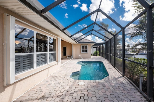 view of swimming pool featuring a lanai, a patio area, and a water view