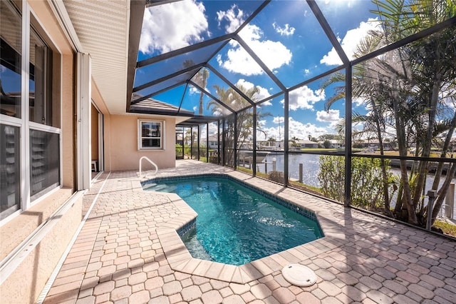 view of pool with a water view, glass enclosure, and a patio area