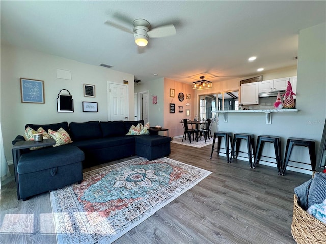 living room with dark wood-type flooring and ceiling fan