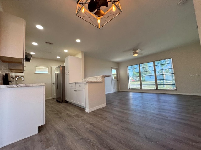 kitchen featuring dark hardwood / wood-style floors, stainless steel refrigerator, white cabinetry, sink, and ceiling fan