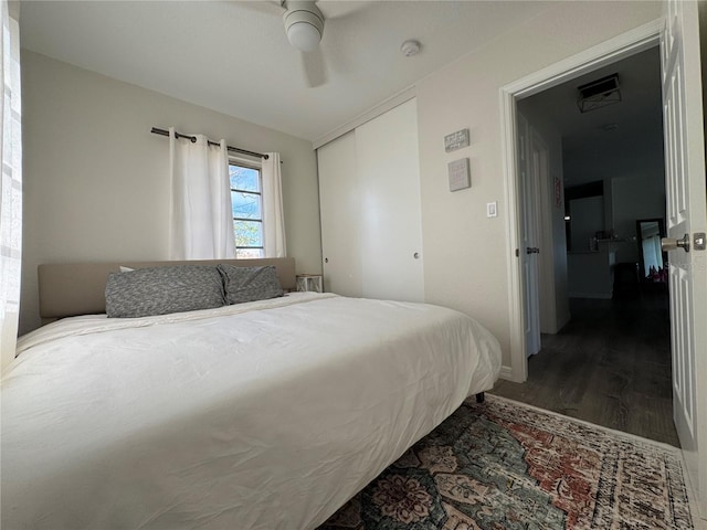 bedroom with a closet, dark hardwood / wood-style floors, and ceiling fan