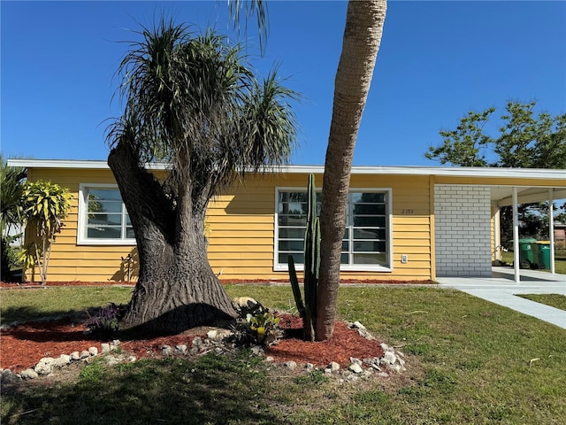 view of side of home featuring a lawn and a carport