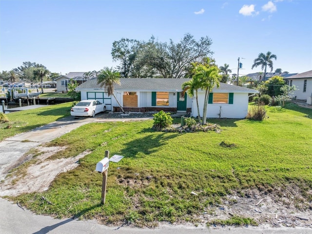 ranch-style house with a garage and a front lawn