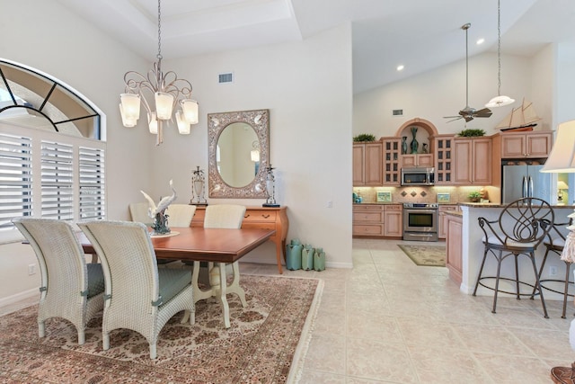 dining space with light tile patterned flooring, ceiling fan with notable chandelier, and high vaulted ceiling