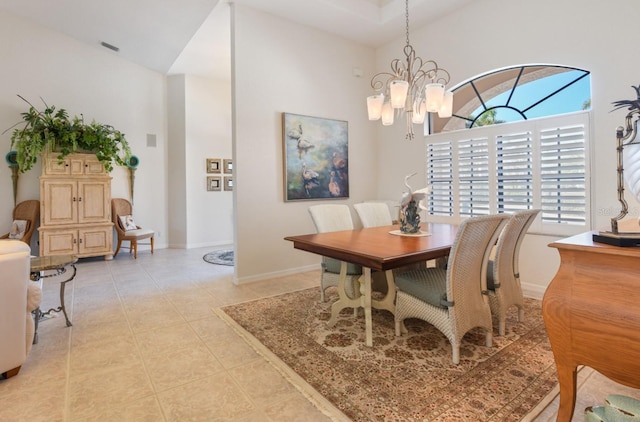 dining area featuring a notable chandelier, a high ceiling, and light tile patterned floors