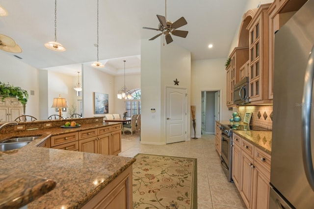 kitchen with tasteful backsplash, sink, hanging light fixtures, light tile patterned floors, and stainless steel appliances