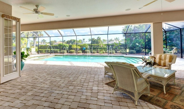 view of swimming pool featuring pool water feature, a patio, a lanai, and ceiling fan