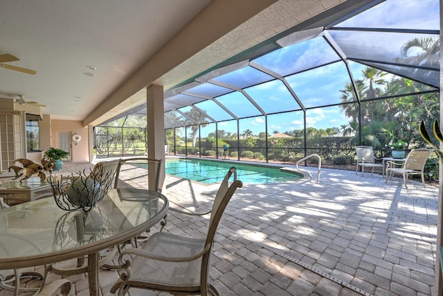 view of swimming pool featuring ceiling fan, a lanai, and a patio