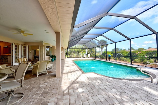 view of swimming pool featuring pool water feature, ceiling fan, a lanai, and a patio area