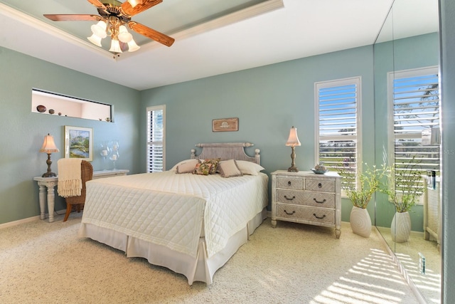 bedroom featuring a raised ceiling and ceiling fan