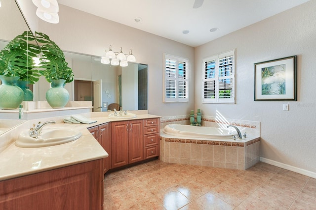 bathroom featuring tile patterned flooring, vanity, and tiled bath