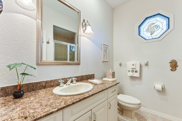 bathroom featuring vanity, toilet, and a shower with shower door