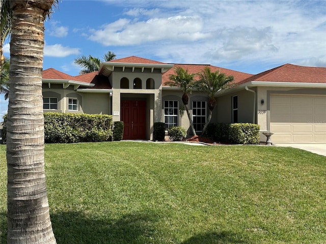 mediterranean / spanish home featuring a garage, a front lawn, and stucco siding