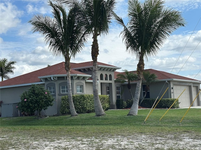 view of front of property featuring a garage, a front lawn, and stucco siding