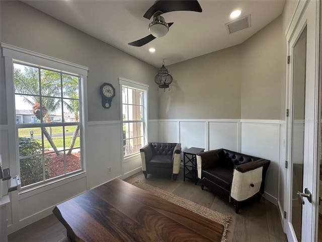 living area with a healthy amount of sunlight, visible vents, and wood finished floors