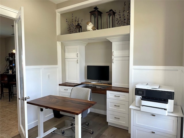 office area with a wainscoted wall, a decorative wall, and wood finished floors