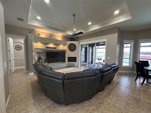 tiled living area featuring a tray ceiling, visible vents, and crown molding