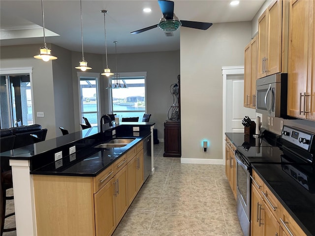 kitchen featuring a breakfast bar, a sink, baseboards, appliances with stainless steel finishes, and an island with sink