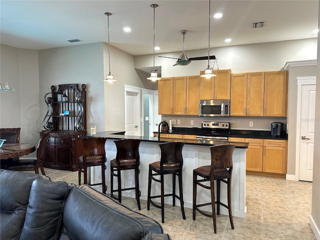 kitchen with open floor plan, appliances with stainless steel finishes, dark countertops, and visible vents