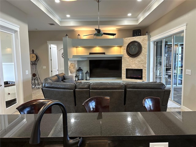 living room with ornamental molding, recessed lighting, and a raised ceiling