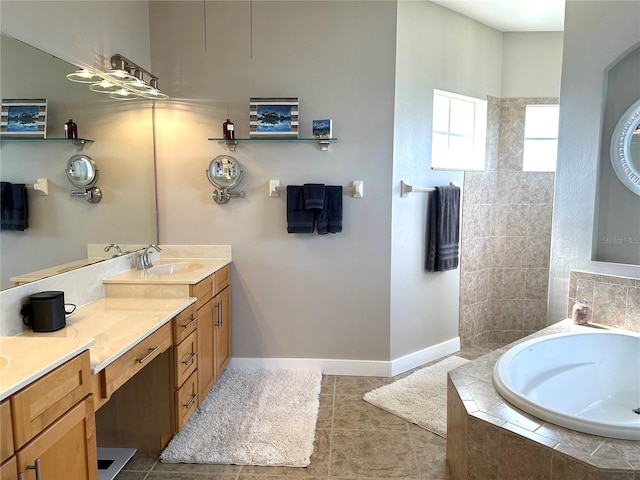 bathroom with tile patterned flooring, a garden tub, vanity, and baseboards