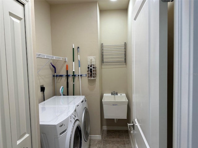 clothes washing area with laundry area, a sink, baseboards, tile patterned floors, and washer and clothes dryer