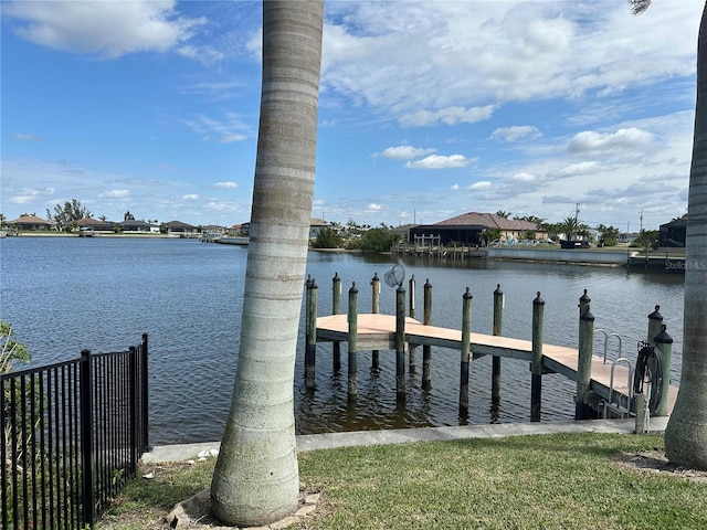 dock area with a water view and fence