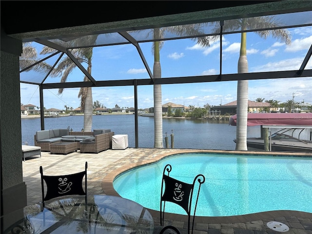 pool with glass enclosure, a patio area, a water view, and an outdoor hangout area