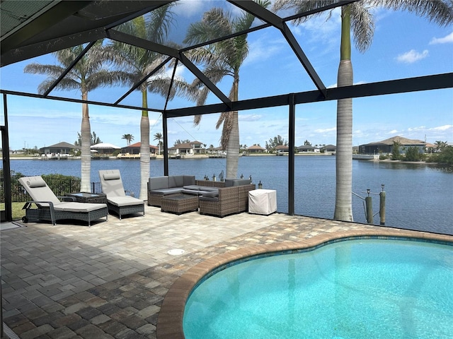 outdoor pool with a water view, glass enclosure, an outdoor hangout area, and a patio