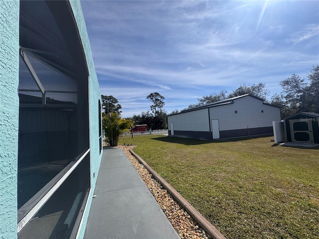 view of side of home with an outbuilding, a lawn, and a lanai