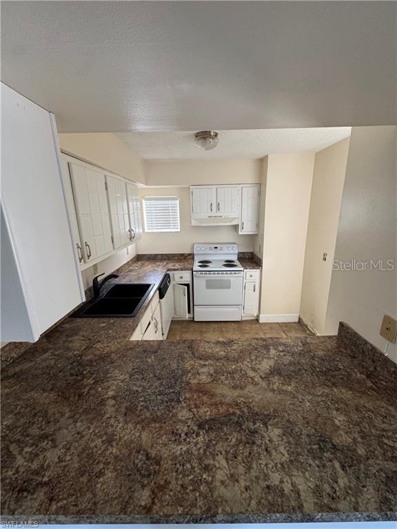 kitchen featuring sink, white appliances, kitchen peninsula, and white cabinets