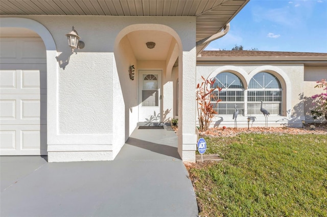 doorway to property featuring a garage and a yard