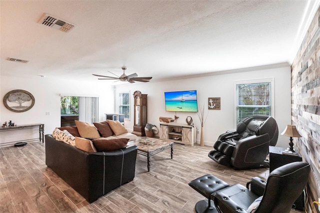 living room with wood tiled floor, visible vents, and a textured ceiling