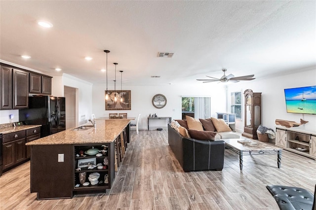 living room with visible vents, a ceiling fan, light wood-style flooring, a textured ceiling, and recessed lighting