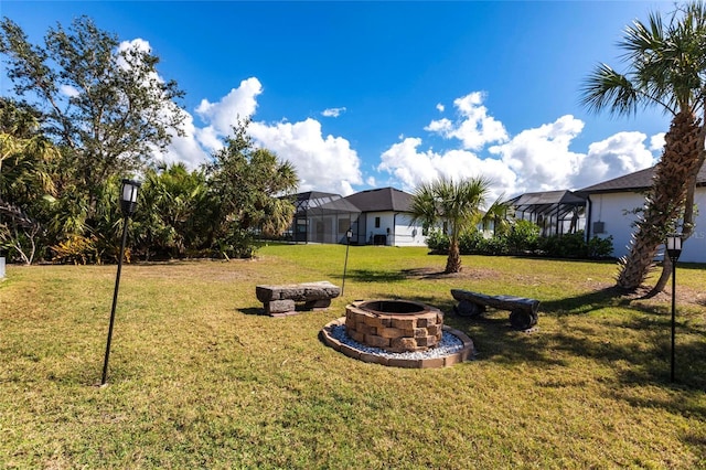 view of yard with glass enclosure and a fire pit