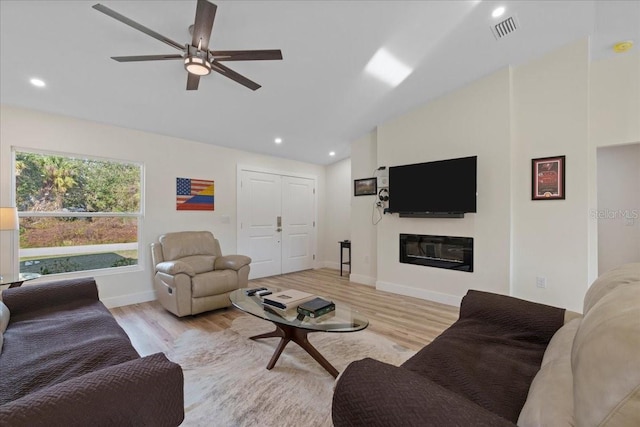 living room with vaulted ceiling, ceiling fan, and light hardwood / wood-style floors