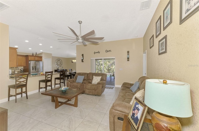 tiled living room featuring lofted ceiling, a textured ceiling, and ceiling fan