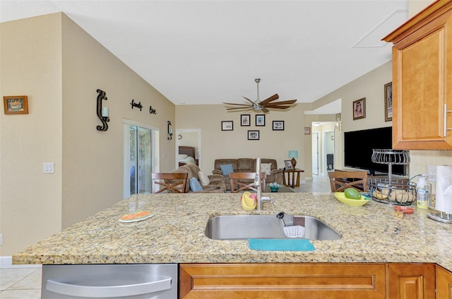 kitchen featuring dishwasher, ceiling fan, sink, and light stone counters