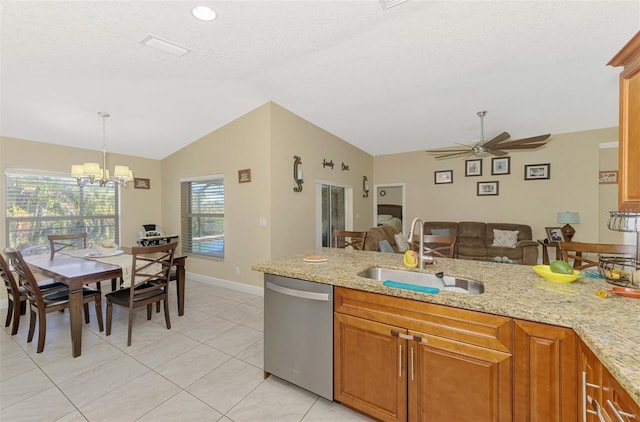 kitchen with light stone counters, dishwasher, sink, and hanging light fixtures