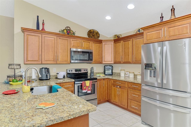 kitchen with sink, vaulted ceiling, light tile patterned floors, appliances with stainless steel finishes, and light stone countertops