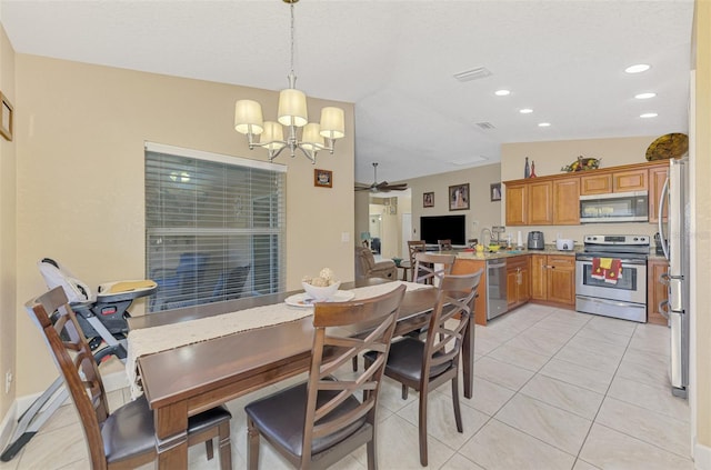 tiled dining room featuring sink and ceiling fan with notable chandelier