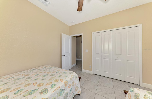 tiled bedroom with ceiling fan and a closet