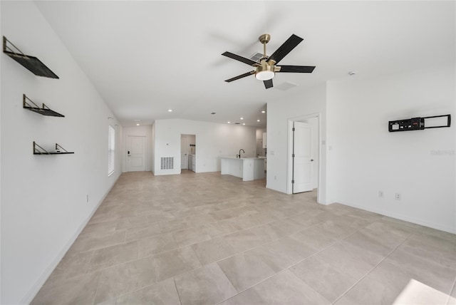 unfurnished living room with light tile patterned flooring, lofted ceiling, sink, and ceiling fan