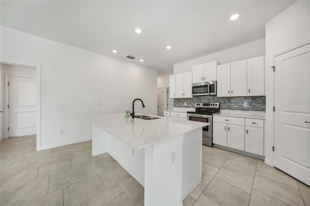 kitchen with sink, an island with sink, white cabinets, and appliances with stainless steel finishes