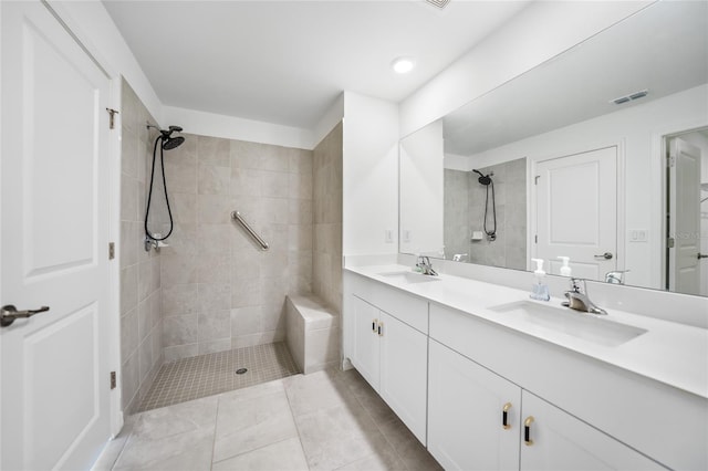 bathroom featuring vanity, tile patterned flooring, and a tile shower