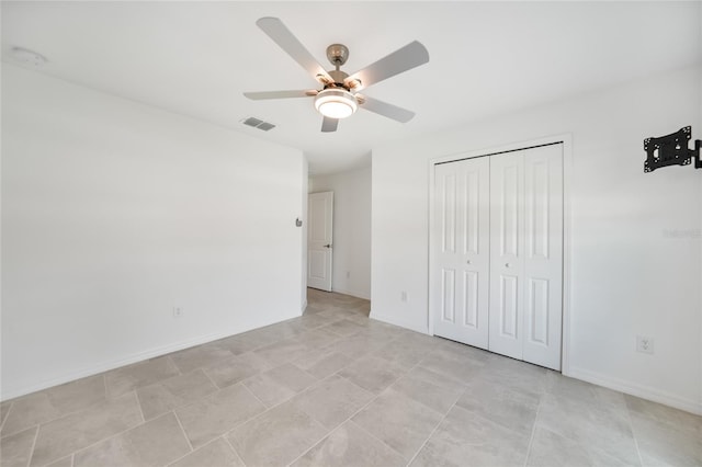 unfurnished bedroom featuring ceiling fan and a closet