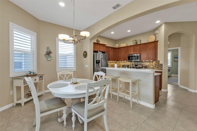 dining area with a chandelier and light tile patterned flooring