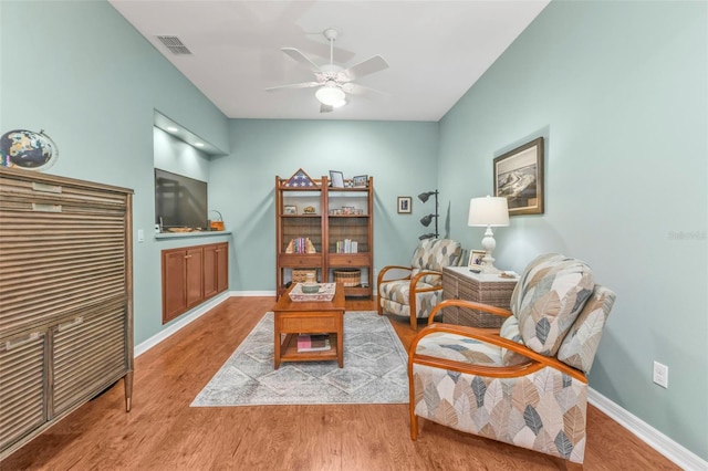 living area featuring ceiling fan and light hardwood / wood-style floors