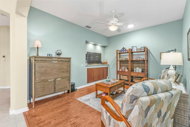 living room with light hardwood / wood-style flooring and ceiling fan